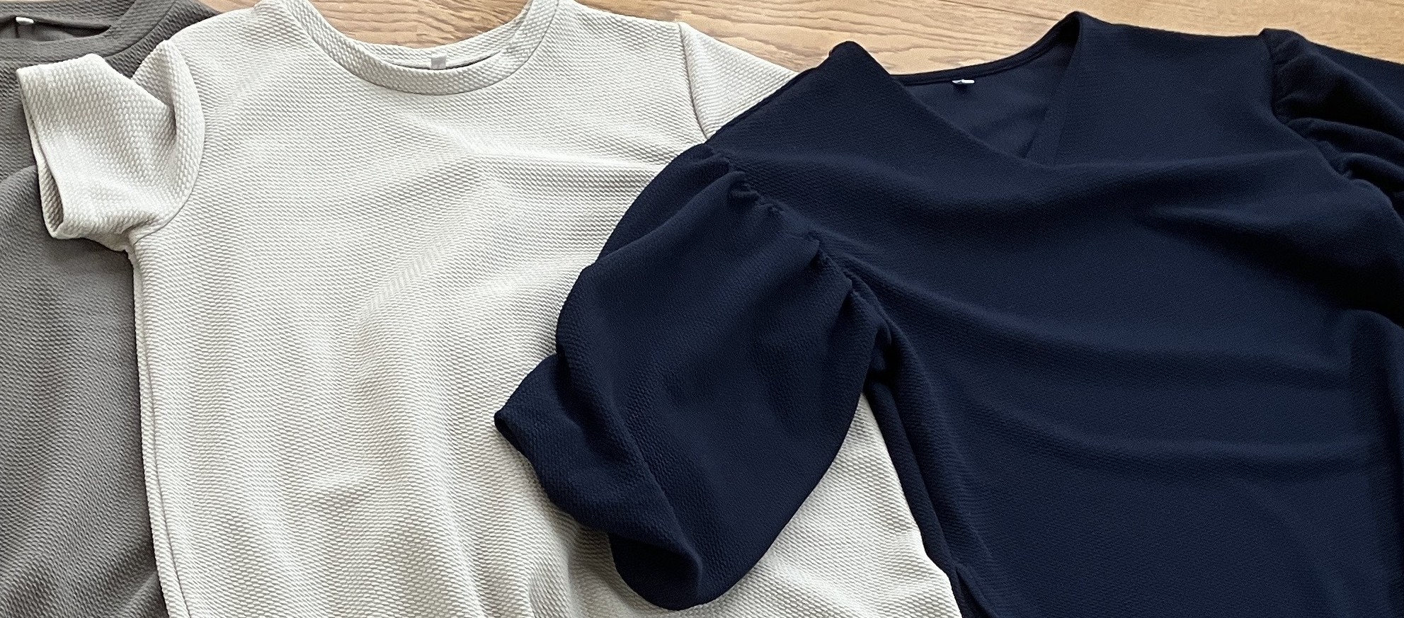 cocaエンボスシリーズの服をまとめて並べた写真。乾燥機にかけてもシワにならないのが特徴